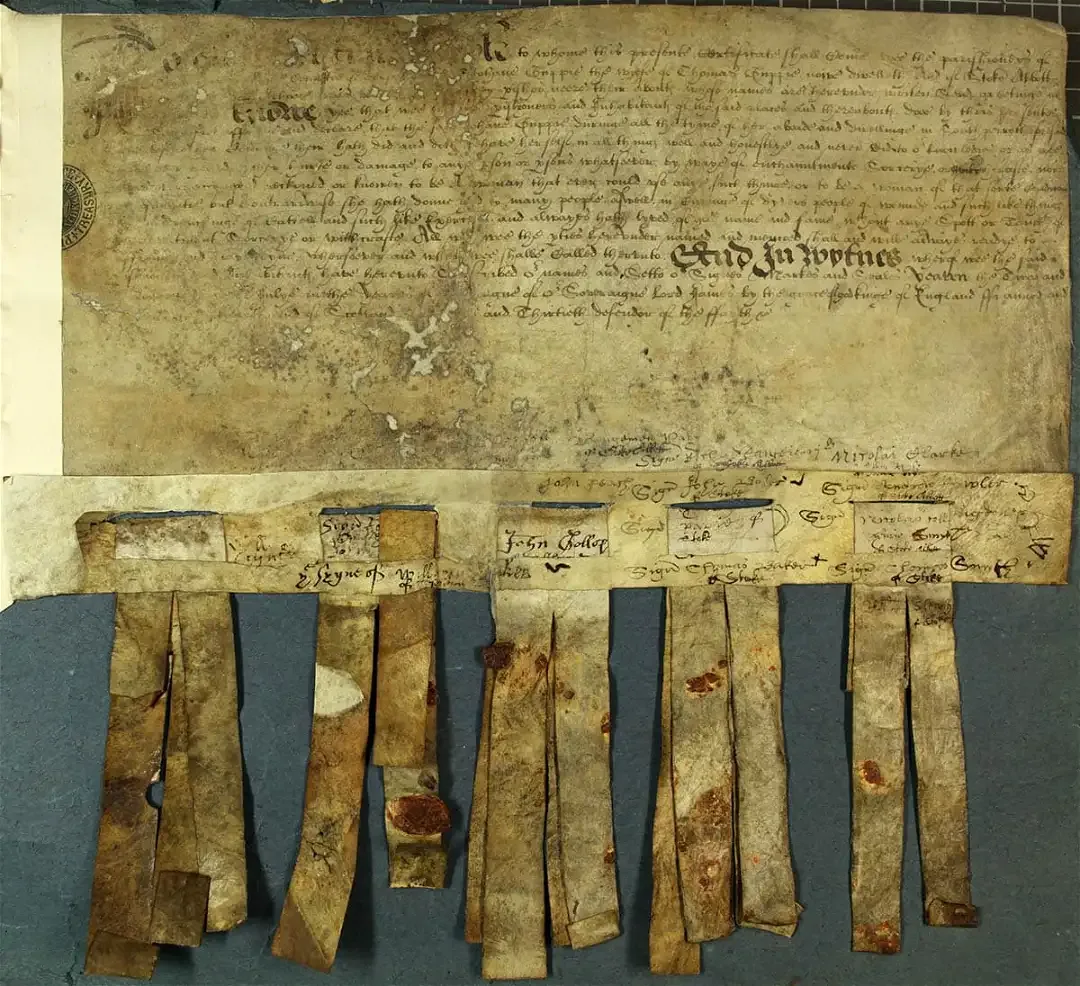 Os vizinhos de uma suspeita de bruxa nem sempre eram hostis a eles. Este documento (que está fortemente danificado em alguns lugares) é o certificado de alguns dos habitantes de South Perrot, Dorset, afirmando que Joan Guppie não era uma bruxa , 1606, via National Archives UK